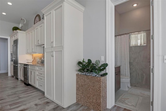 kitchen featuring white cabinetry, light wood-style flooring, recessed lighting, and stainless steel appliances