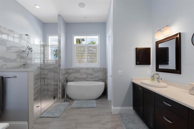 bathroom featuring vanity, a stall shower, marble finish floor, and a freestanding bath