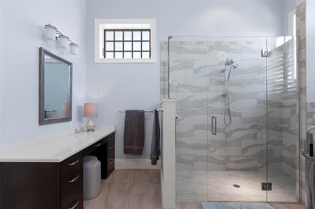 full bathroom featuring vanity, a shower stall, and marble finish floor