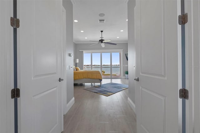 corridor with recessed lighting, light wood-type flooring, baseboards, and crown molding