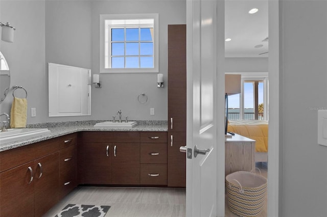 bathroom featuring double vanity, ensuite bathroom, and a sink