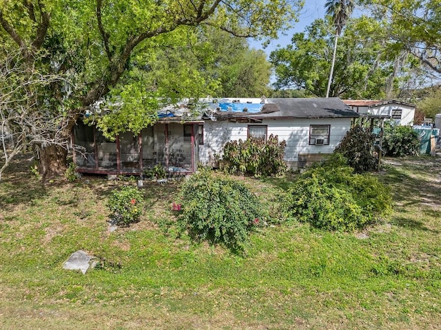 view of front of property featuring a front lawn and a sunroom