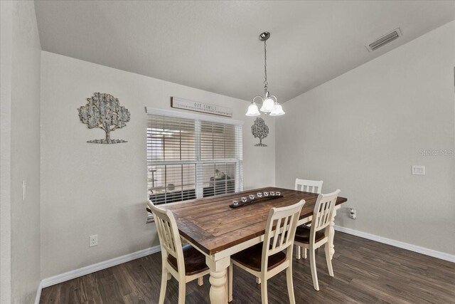 dining area featuring visible vents, baseboards, wood finished floors, and a chandelier