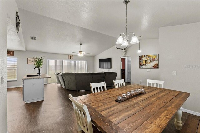 dining area with visible vents, baseboards, lofted ceiling, ceiling fan with notable chandelier, and a textured ceiling