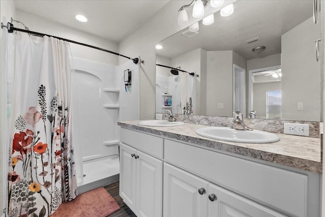 bathroom featuring a shower with curtain, visible vents, and a sink