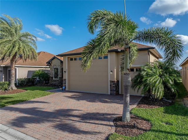 view of front of property featuring stone siding, stucco siding, decorative driveway, and a garage