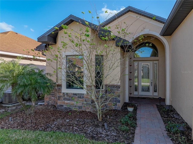 entrance to property with stone siding and stucco siding