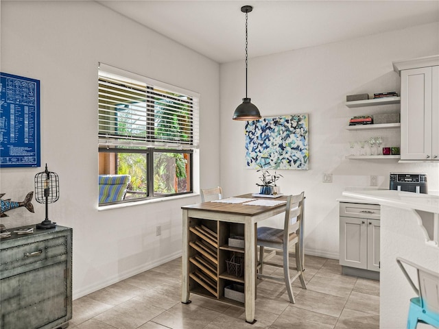 kitchen with pendant lighting, open shelves, white cabinetry, light countertops, and baseboards