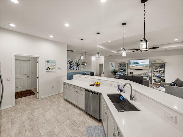 kitchen featuring pendant lighting, a sink, open floor plan, light countertops, and dishwasher