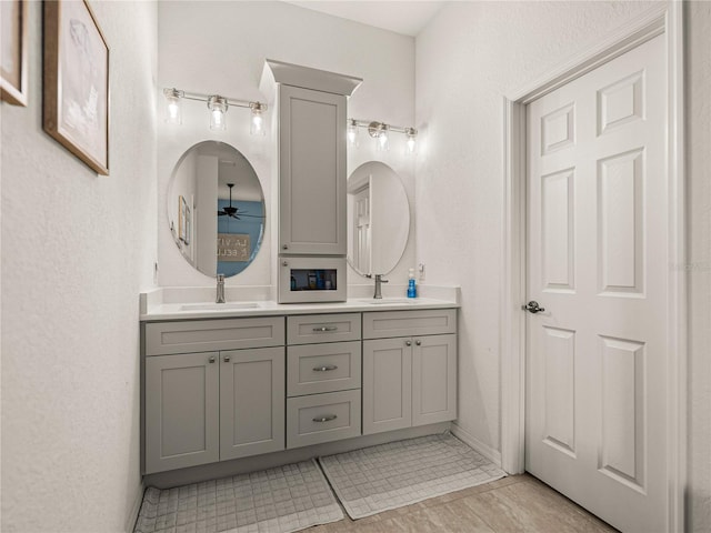 full bathroom with a sink, a ceiling fan, and double vanity