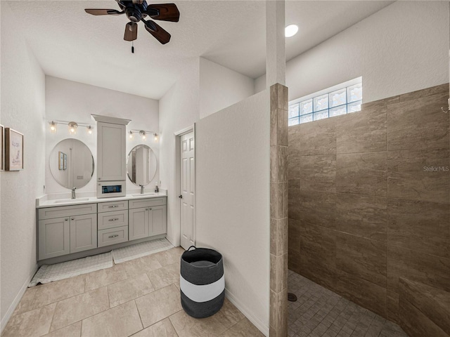 bathroom featuring tile patterned floors, a ceiling fan, a walk in shower, a sink, and double vanity