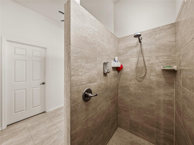 full bathroom featuring tile patterned flooring and a tile shower