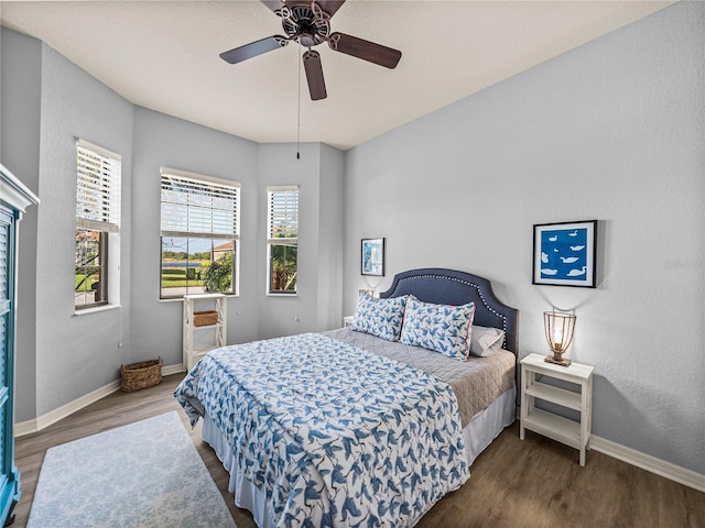 bedroom featuring a ceiling fan, baseboards, and wood finished floors