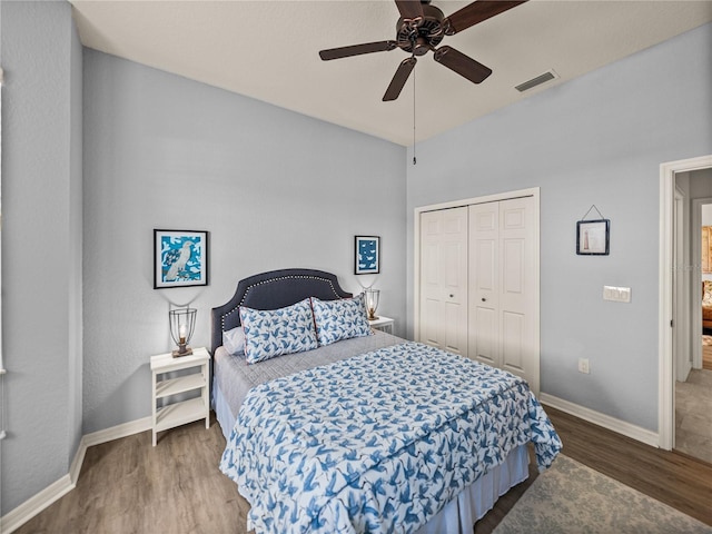 bedroom featuring visible vents, wood finished floors, a closet, baseboards, and ceiling fan