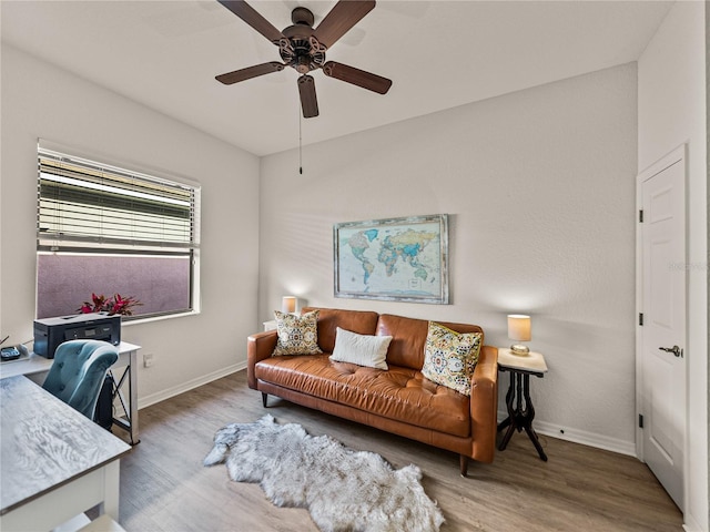 living area with ceiling fan, baseboards, and wood finished floors