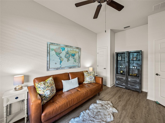 living room featuring visible vents, ceiling fan, baseboards, and wood finished floors