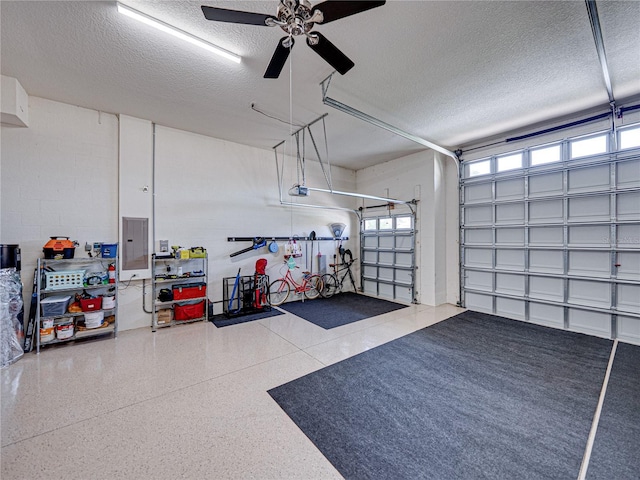 garage featuring electric panel, a garage door opener, and ceiling fan