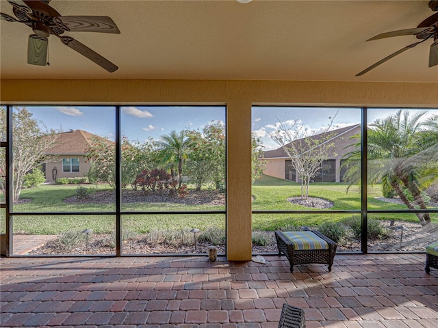 unfurnished sunroom featuring a ceiling fan