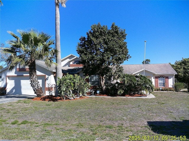 view of front of home featuring a front lawn, an attached garage, and driveway