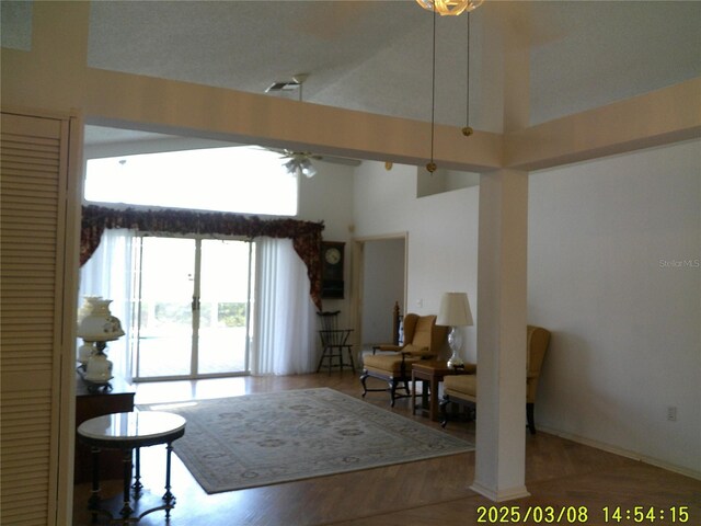 living room featuring high vaulted ceiling, wood finished floors, and a ceiling fan