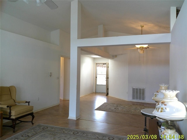 foyer entrance with wood finished floors, baseboards, visible vents, high vaulted ceiling, and ceiling fan