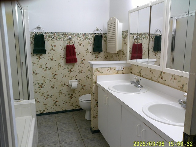 bathroom featuring tile patterned flooring, wallpapered walls, and a sink