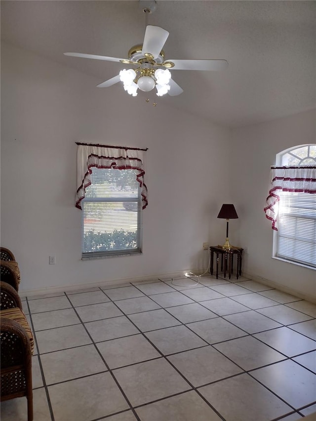 tiled spare room with ceiling fan