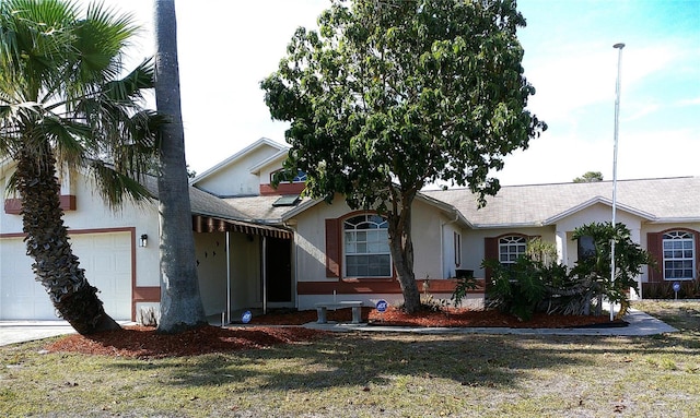 ranch-style house featuring an attached garage, a shingled roof, and stucco siding