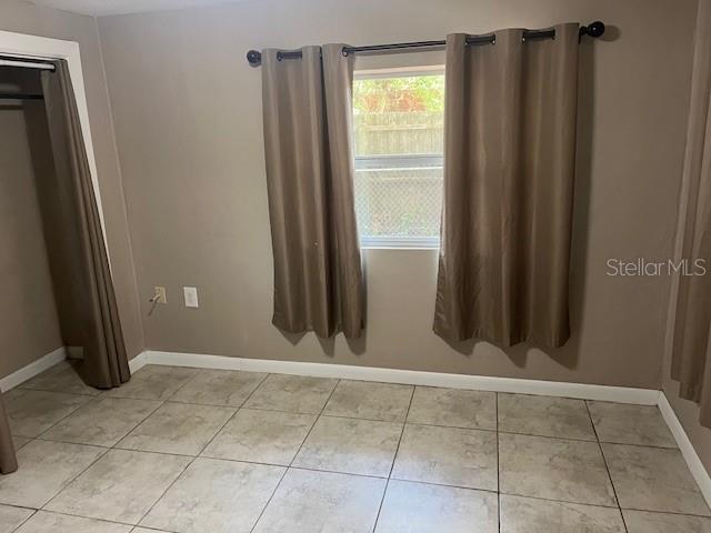 interior space with baseboards and light tile patterned flooring