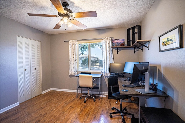 office featuring baseboards, a textured ceiling, wood finished floors, and a ceiling fan