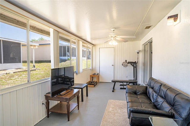 living area with visible vents, plenty of natural light, concrete flooring, and a ceiling fan