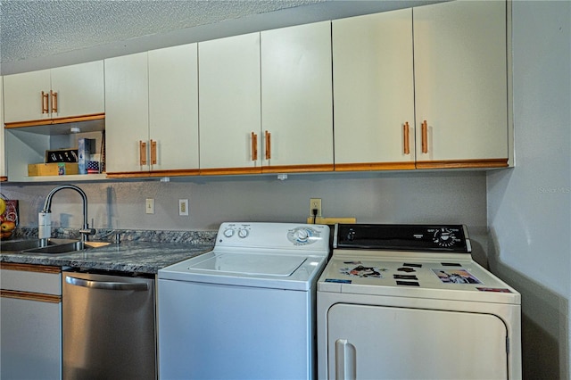 washroom with laundry area, washer and dryer, and a sink