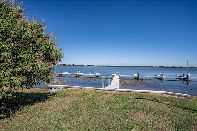 dock area featuring a lawn and a water view