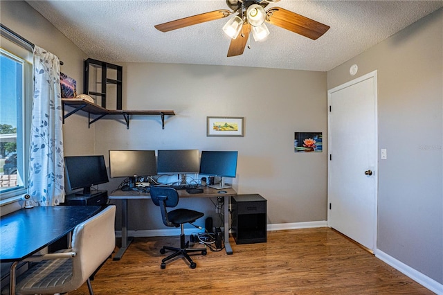 office space with baseboards, a textured ceiling, wood finished floors, and a ceiling fan