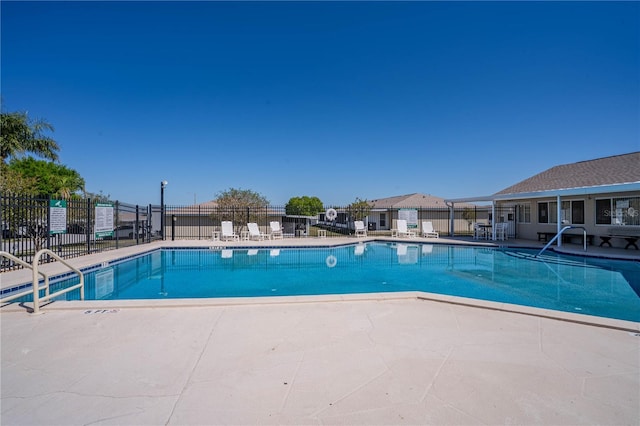 pool with a patio and fence