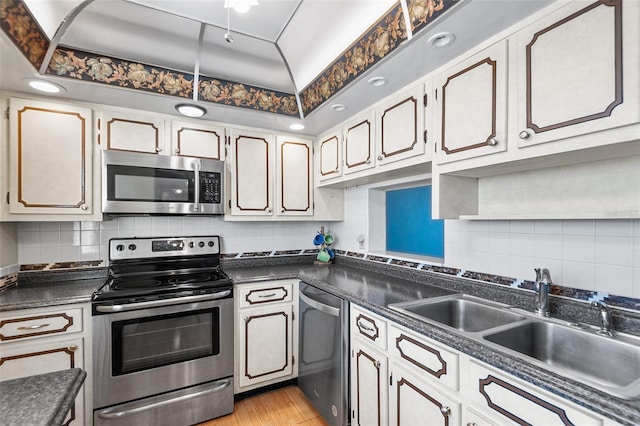 kitchen featuring dark countertops, appliances with stainless steel finishes, and a sink