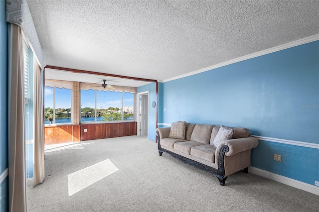 living area with baseboards, a textured ceiling, ornamental molding, and carpet flooring