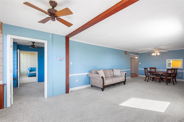 carpeted living area featuring ceiling fan, baseboards, and ornamental molding