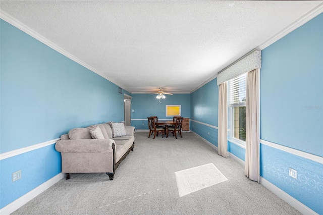 living room featuring baseboards, carpet, ornamental molding, and a textured ceiling