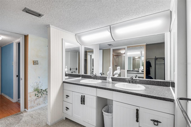 bathroom with a sink, visible vents, and a textured ceiling