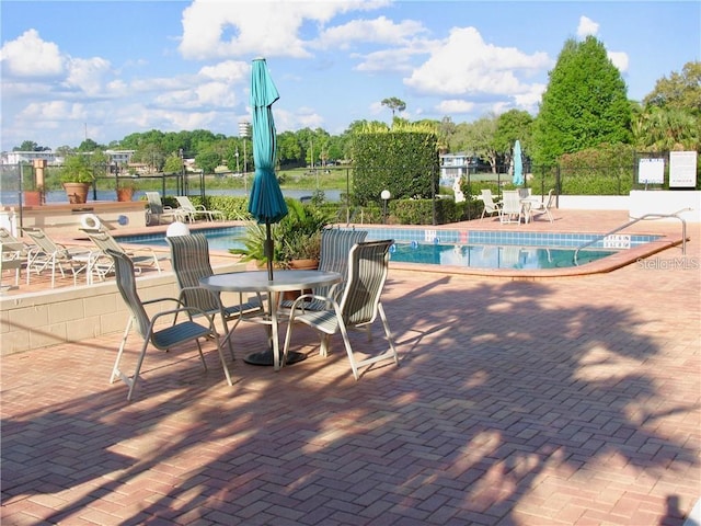 pool with a patio and fence