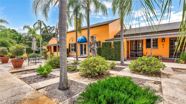 view of front of home featuring stucco siding, french doors, and a patio