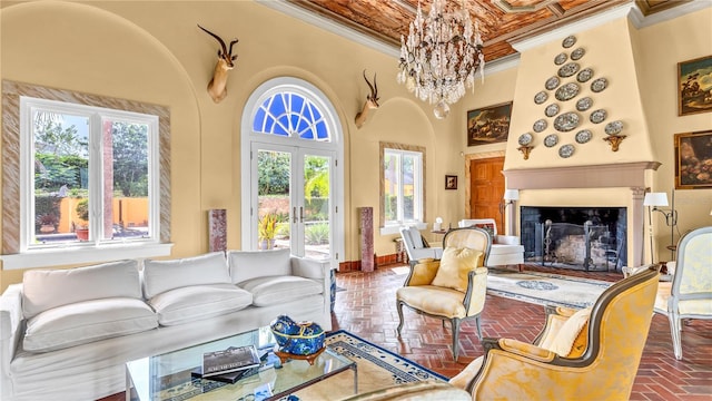 living area with a fireplace with raised hearth, a healthy amount of sunlight, french doors, and ornamental molding