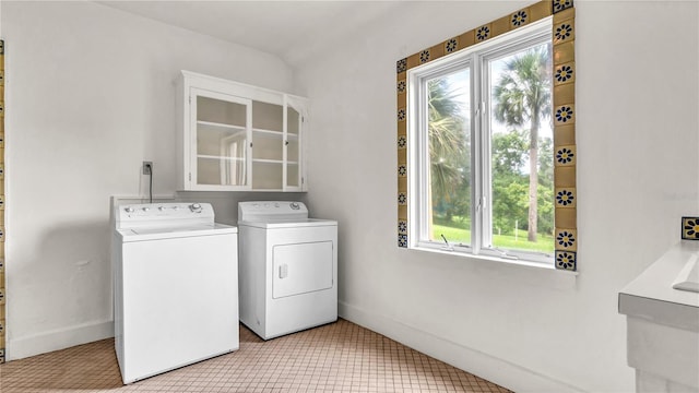 laundry room featuring laundry area, baseboards, independent washer and dryer, and tile patterned floors