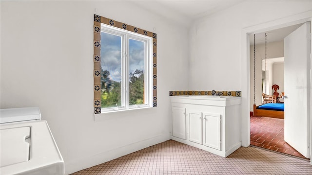 laundry room with brick floor and a sink