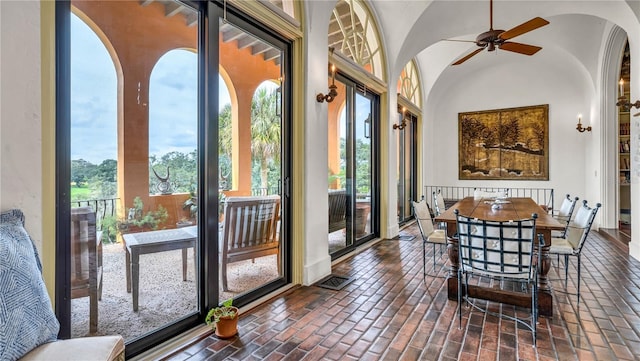 sunroom / solarium with visible vents, a ceiling fan, and vaulted ceiling