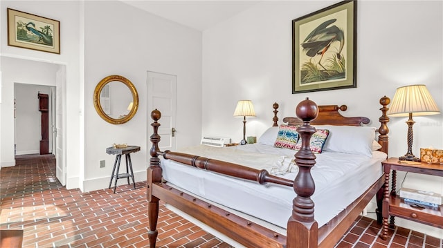 bedroom with baseboards and brick floor