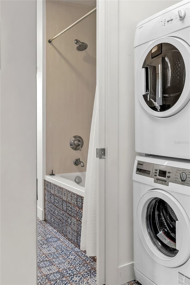 laundry room featuring stacked washer and dryer and tile patterned flooring