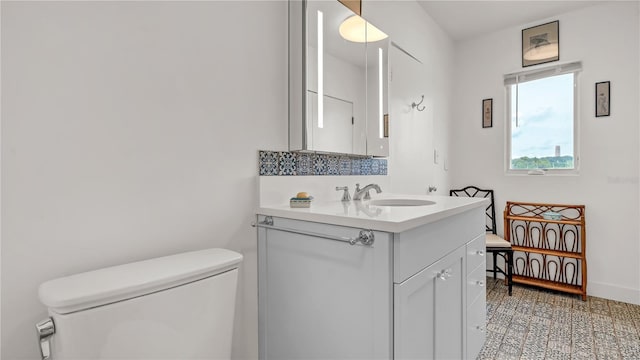 half bath with vanity, toilet, and baseboards