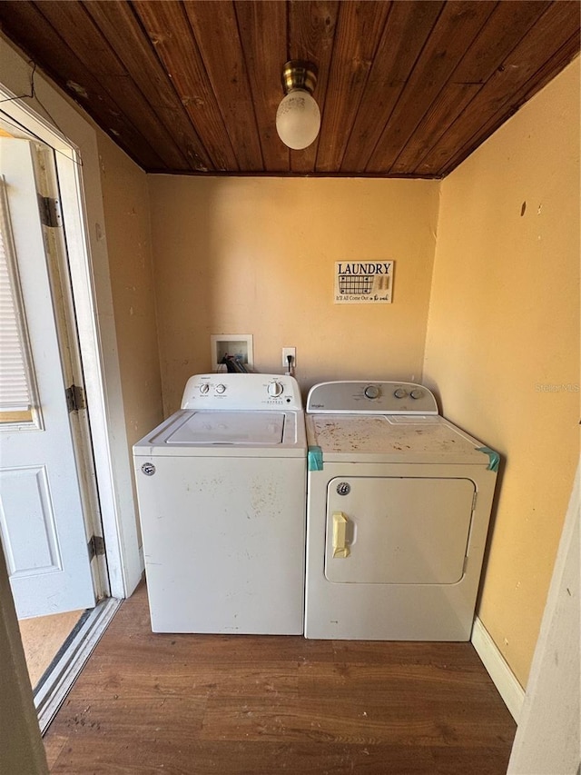 clothes washing area featuring wood ceiling, wood finished floors, laundry area, and washing machine and clothes dryer